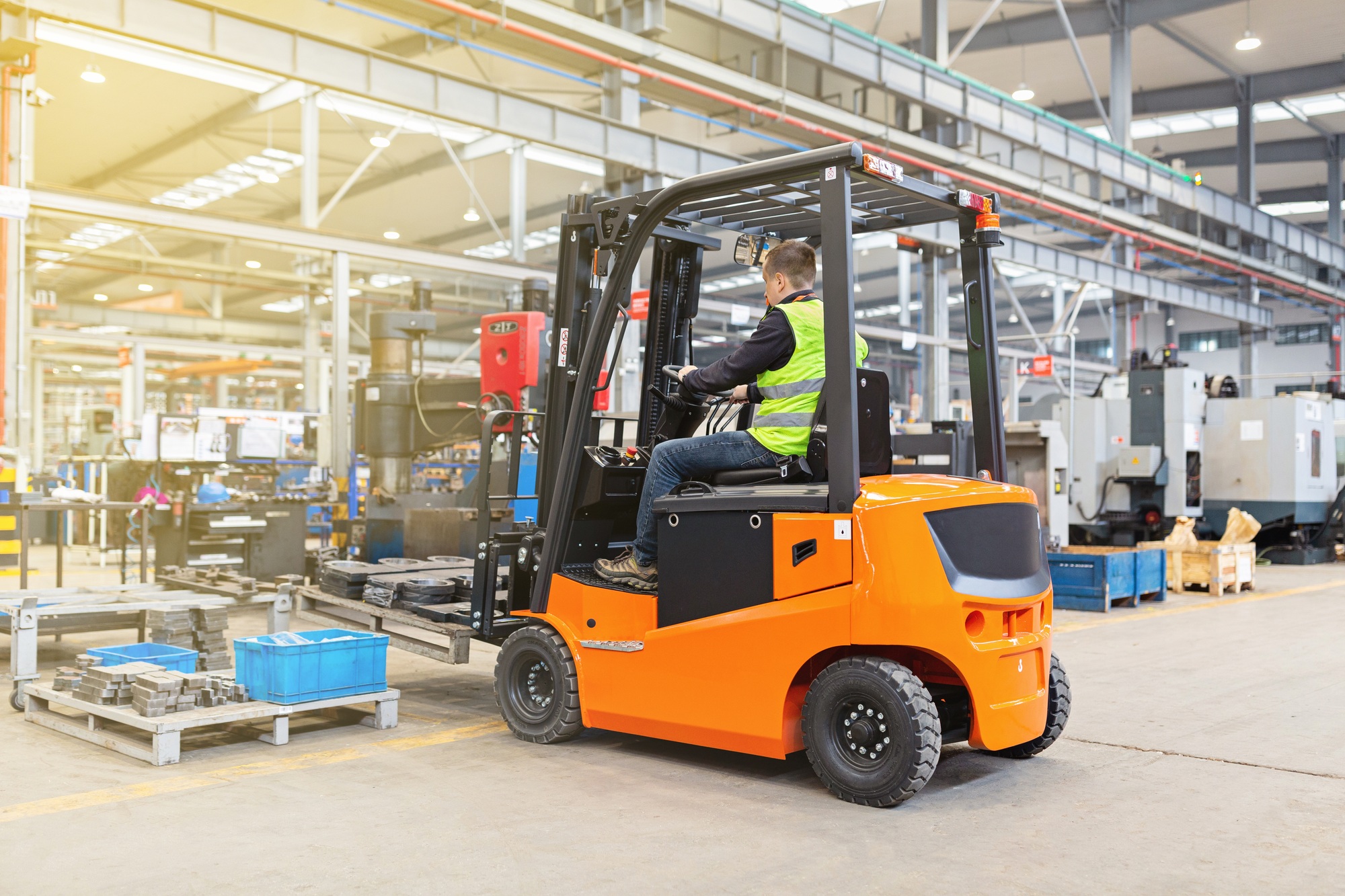 Storehouse employee in uniform working on forklift in modern automatic warehouse